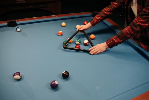 Person setting up an american style pool table