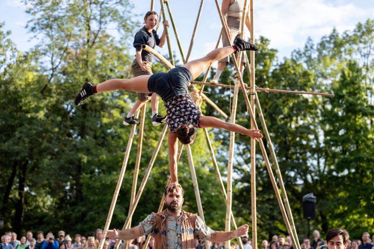 Circus performers on long bamboo poles