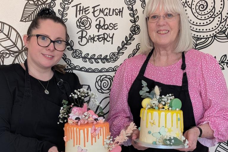 Two women holding drip cakes