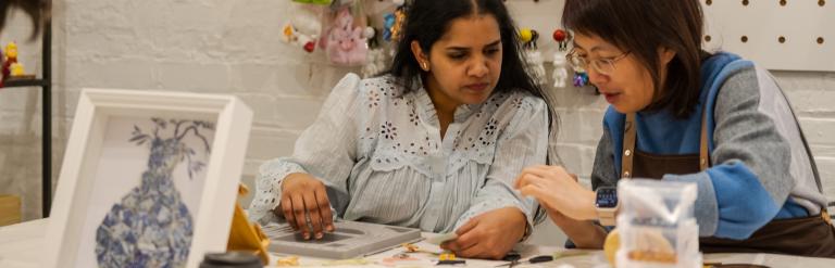 Two women working together at a craft table