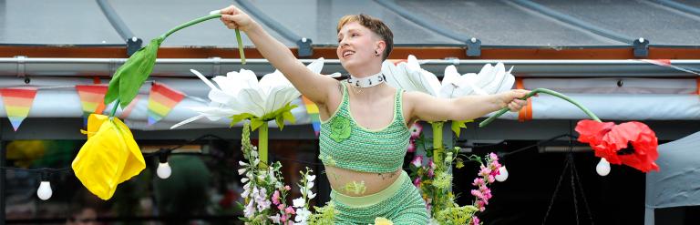 A woman wearing a fairy costume and holding paper flowers