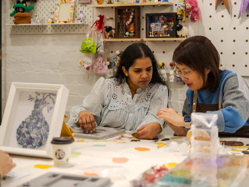 Two women working together at a craft table