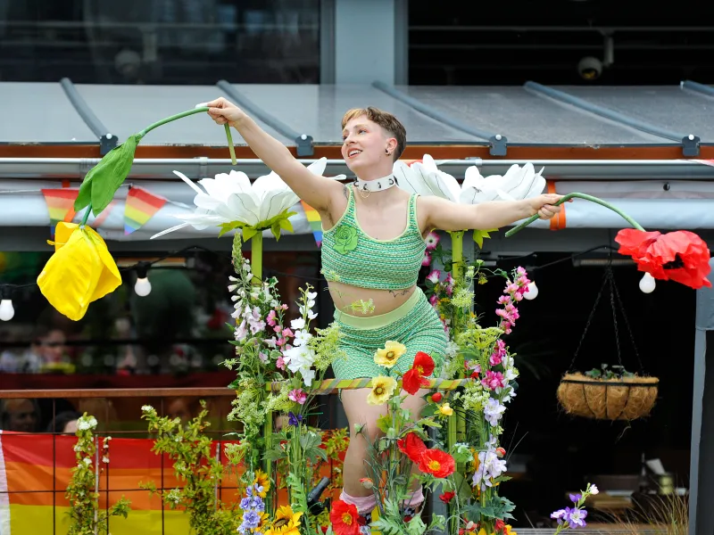 A woman wearing a fairy costume and holding paper flowers