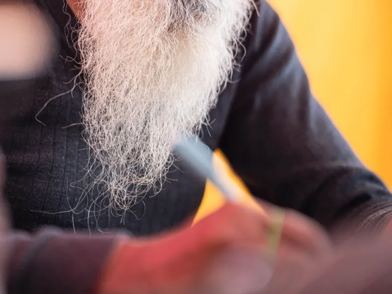 Bearded man writing.
