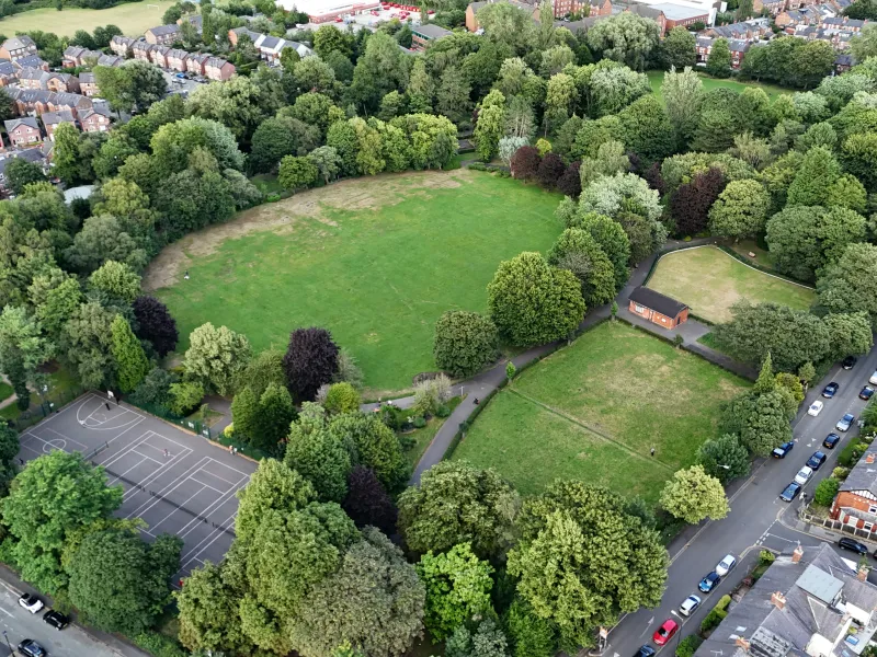 An aerial photo of a park with sports courts and some surrounding streets 