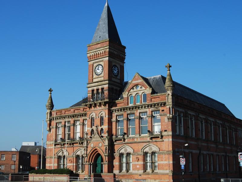 A front side angle of Stretford Public Hall, a Grade 2 listed Victorian building with a clocktower 