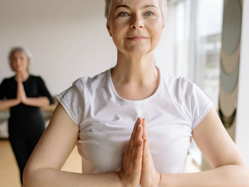 Women with hands together in yoga pose.