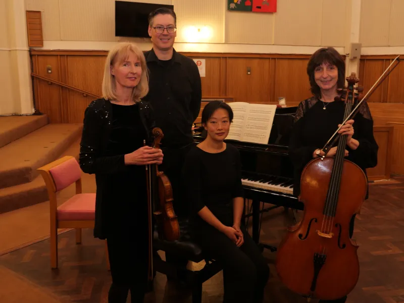 Violinist, cellist and pianist in a modern church