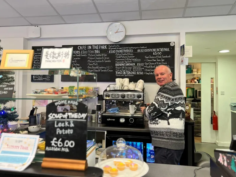 A man standing at a coffee machine in a cafe