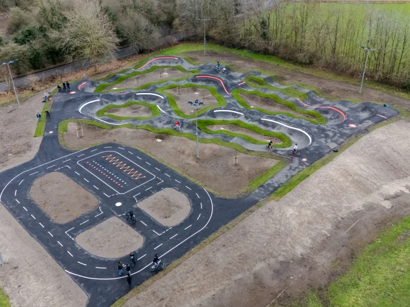An aerial view of a BMX pump track in a park