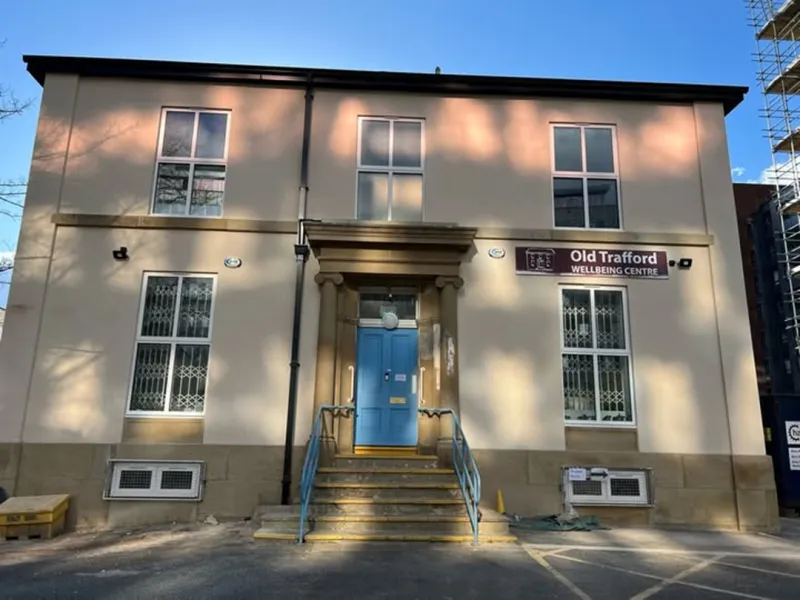 Photo of the front of a cream building, with a blue front door