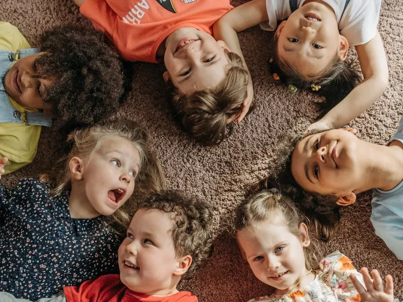 Children lying in a circle laughing.