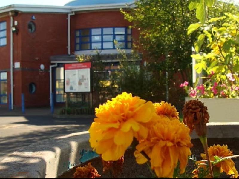 External view of a library entrance and car park