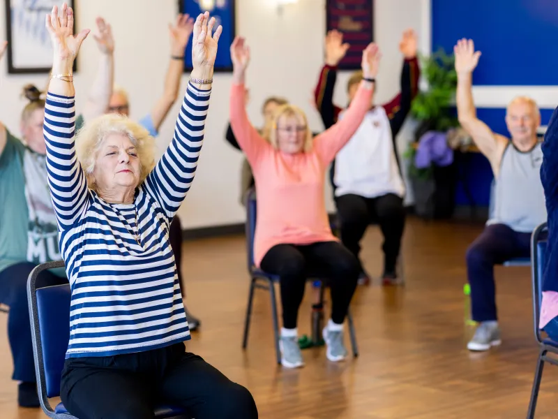 Multiple people sat on chairs, stretching upwards