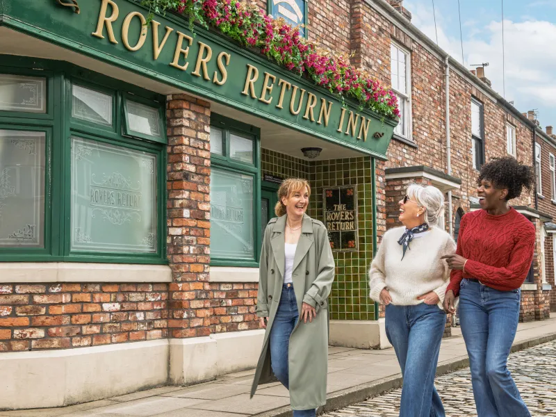 Three people walking outside the Rovers Return