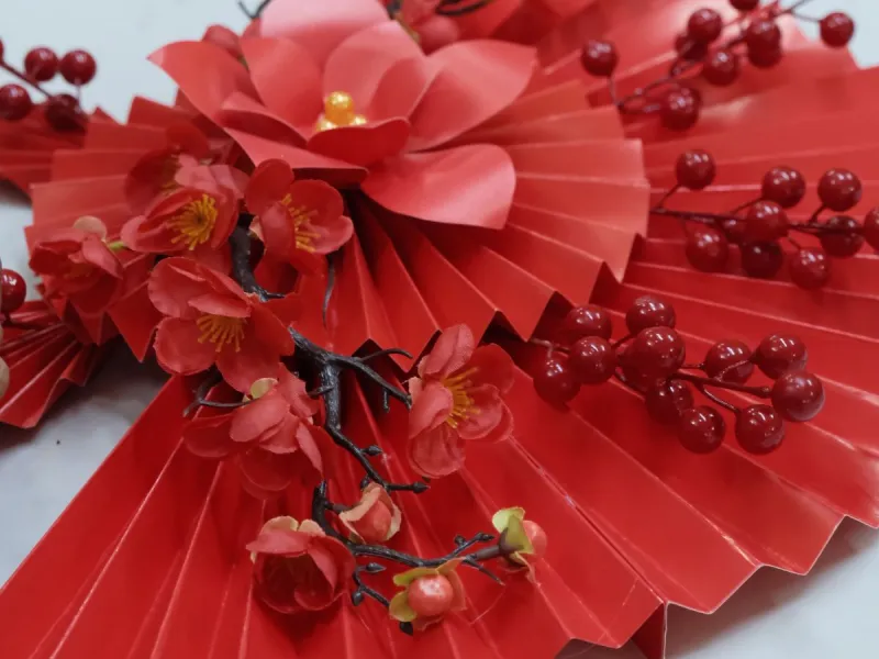A red paper fan on a craft table