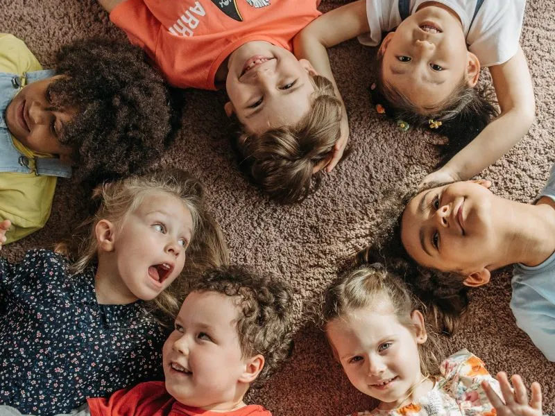 Laughing toddlers lying down in a circle