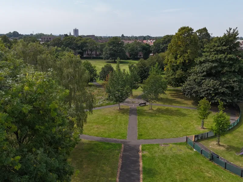 An aerial photo of a park with green trees and lawns