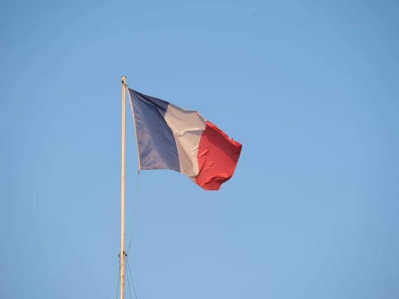 A French flag against a blue sky