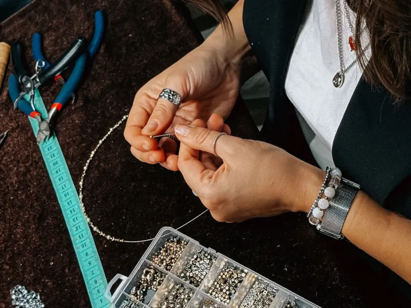 Woman jewellery making with beads.