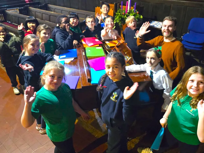 A group of children around a piano
