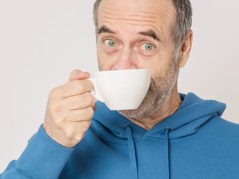 Man holding cup of coffee.