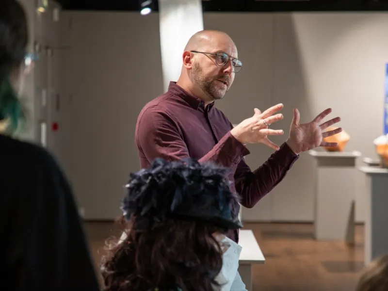 A man explaining something to a group in a gallery