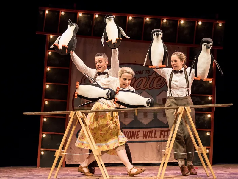 Two performers dancing with model penguins