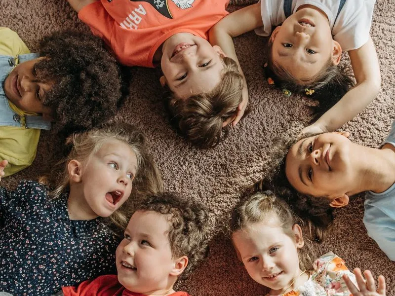 Children lying in a circle laughing.