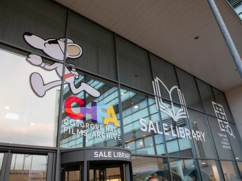 Image of library entrance doors and foyer with etched signs showing cartoon character danger mouse and library name as well as that of Cosgrove Hall Film Archive.