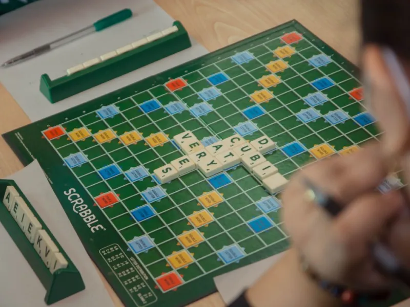 Someone sitting in front of a Scrabble board