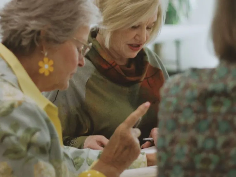Group of ladies discussing a book.