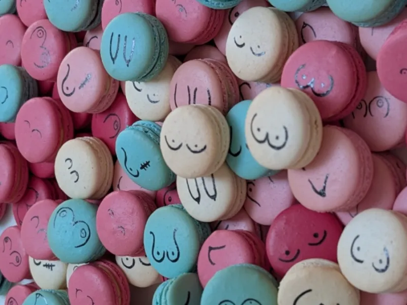 Pink, white and blue macarons with illustrations of breasts on them