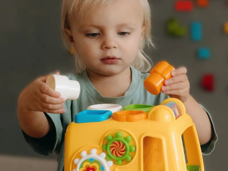 Toddler playing with toy car.