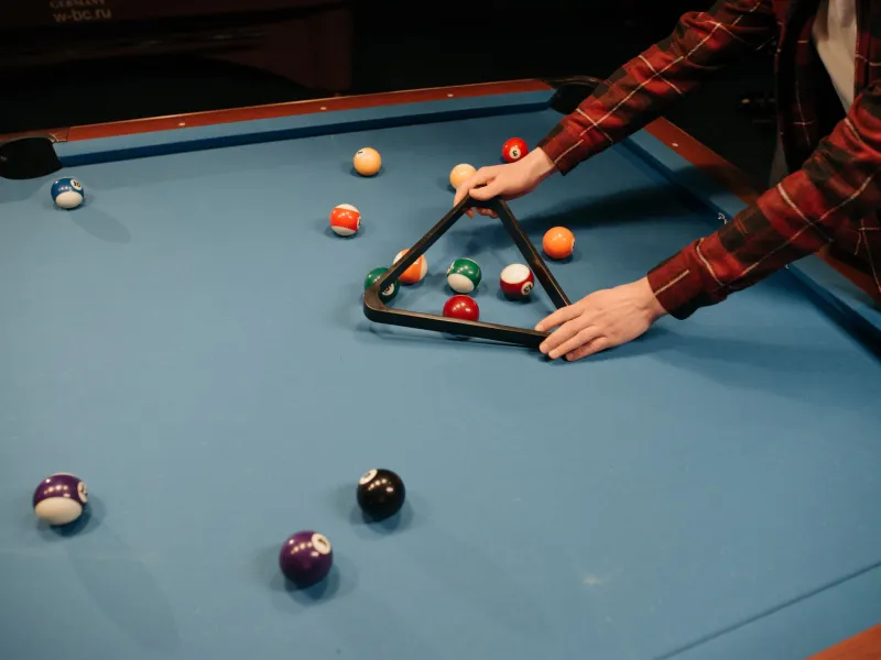 Person setting up an american style pool table
