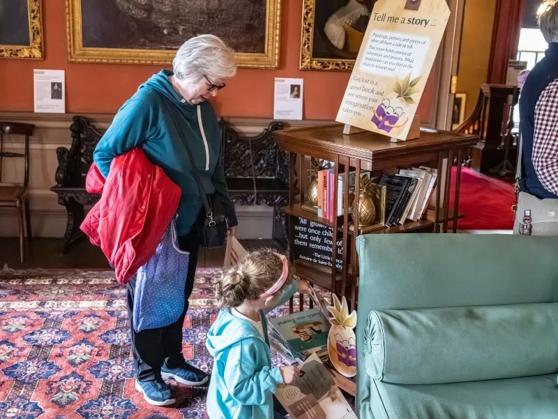 A child and older woman looking at books