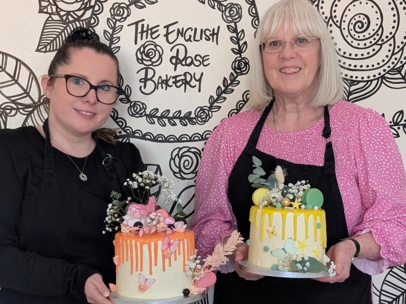 Two women holding drip cakes